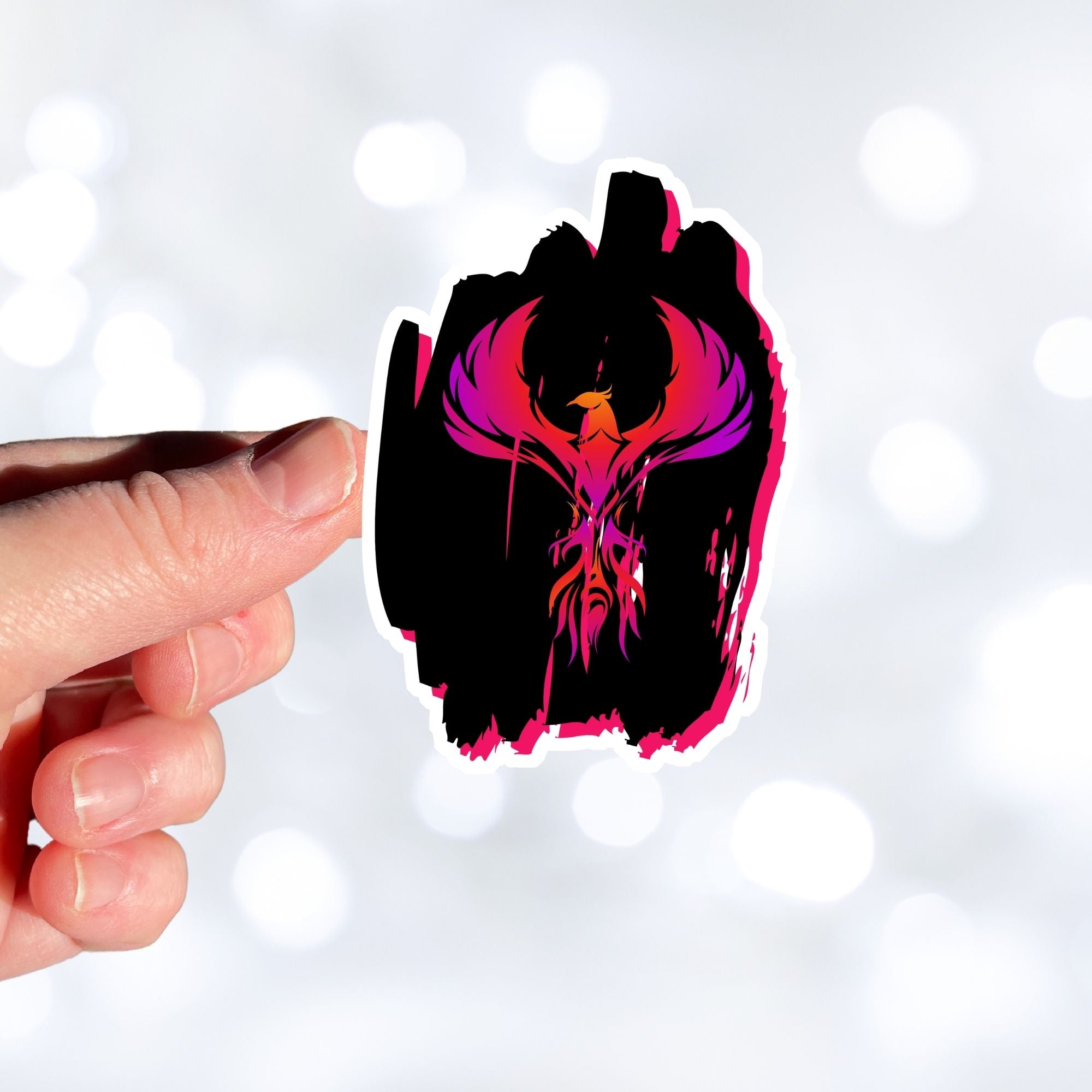 Phoenix rising - this individual die-cut sticker features a purple, red, and orange phoenix on a black background. This image shows a hand holding the Phoenix on Black sticker.
