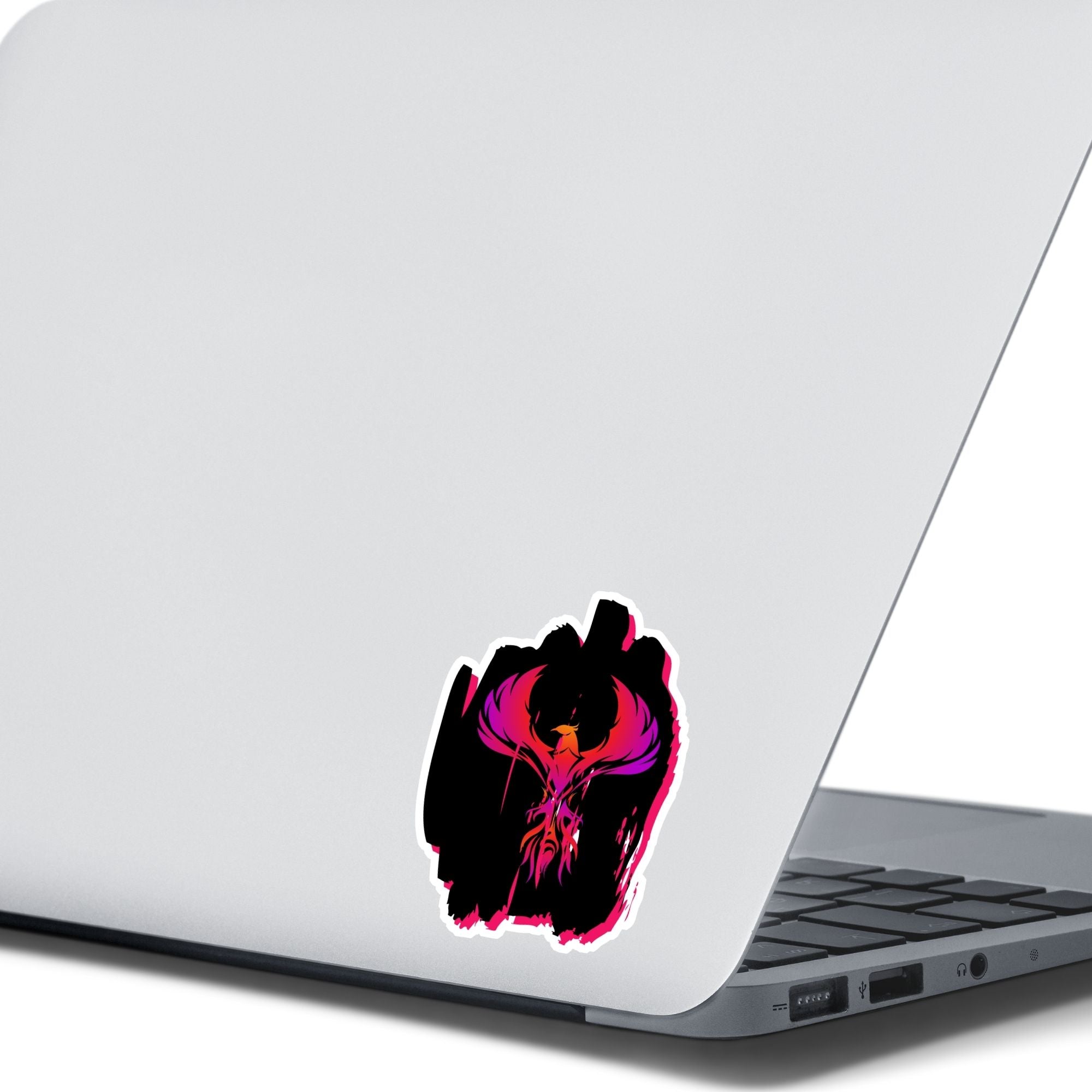 Phoenix rising - this individual die-cut sticker features a purple, red, and orange phoenix on a black background. This image shows the Phoenix on Black die-cut sticker on the back of an open laptop.