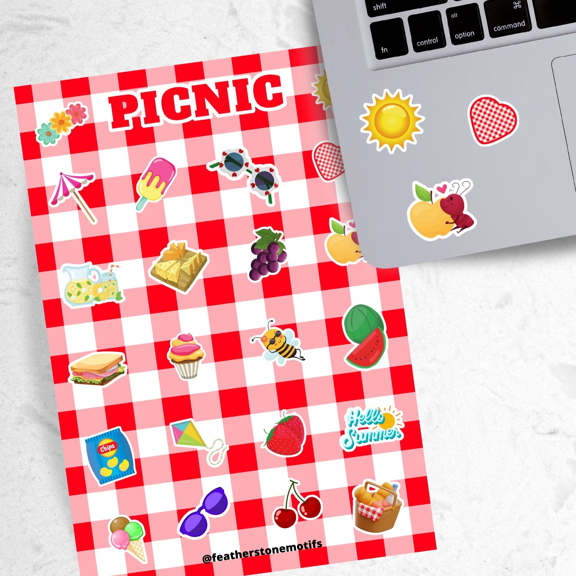 Pack the picnic basket and grab a blanket; we're going on a picnic! This sticker sheet has sticker images of all your favorite picnic foods and activities like sandwiches, fruit, ice cream, and lemonade all on a red and white checked tablecloth background. This image shows the sticker sheet next to an open laptop with stickers of the sun, a red and white checked heart, and an ant holding a yellow apple, applied below the keyboard.