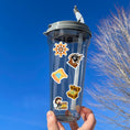 Load image into Gallery viewer, You'll walk the plank to get our A Pirates Life sticker sheet with individual stickers of treasure chests, treasure maps, pirate ships, pirates, and pirate creatures.  This is an image of a water bottle with stickers on it.
