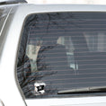 Load image into Gallery viewer, If you think a pirate's life is for you, then this individual die-cut sticker is just what you need! This pirate's life sticker features a jolly rodger (skull and crossed swords) flag with storm clouds and the saying "A Pirate's Life For Me". This image shows the pirate's life sticker on the back window of a car.
