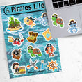 Load image into Gallery viewer, You'll walk the plank to get our A Pirates Life sticker sheet with individual stickers of treasure chests, treasure maps, pirate ships, pirates, and pirate creatures.  This is an image of a laptop with stickers on it.
