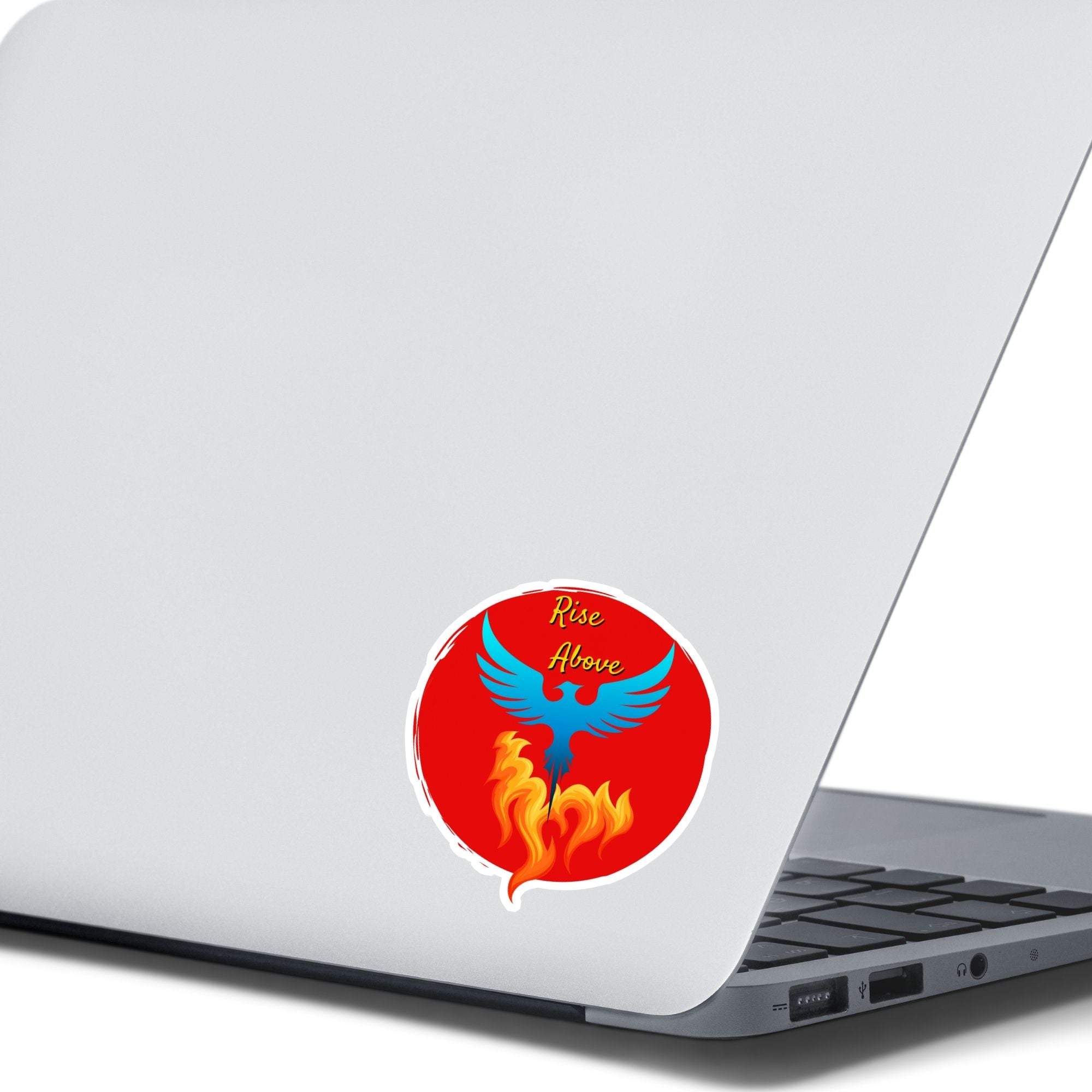 Phoenix rising - this individual die-cut sticker features a blue phoenix rising out of flames with the words "Rise Above" at the top, all on a red background. This image shows the Rise Above die-cut sticker on the back of an open laptop.
