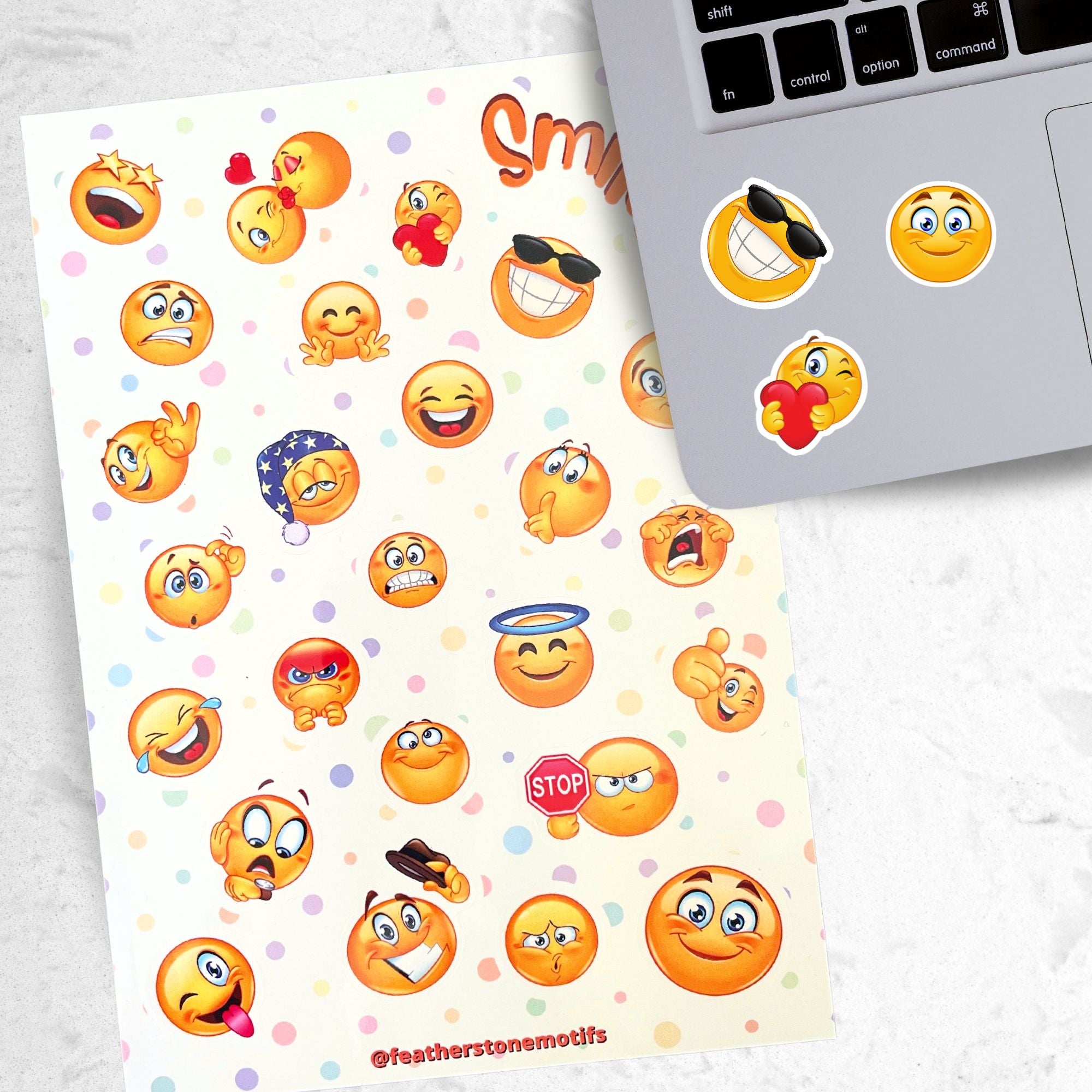 This sticker sheet features all your favorite smiley emojis! It's enough to make anyone smile! This image shows the Smiley sticker sheet next to a laptop with stickers of a smiley face with sunglasses, a blue eyed smiley face, and a smiley face holding a heart applied below the keyboard.