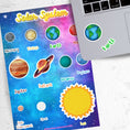 Load image into Gallery viewer, Our solar system - 8 (or 9) planets plus the sun and moon. This sticker sheet is great for class projects or for any aspiring space scientists! Stickers of every planet's image as well as the planet's name - Mercury, Venus, Earth, Mars, Jupiter, Saturn, Uranus, Neptune, and Pluto. This image shows the sticker sheet next to an open laptop with stickers of Earth's image and Name applied below the keyboard.
