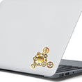 Load image into Gallery viewer, Nothing is more iconic for steampunk than gears and clocks. The steampunk gears individual die-cut sticker is a classic steampunk type image with gears and clocks. This image shows the steampunk gears sticker on the back of an open laptop.
