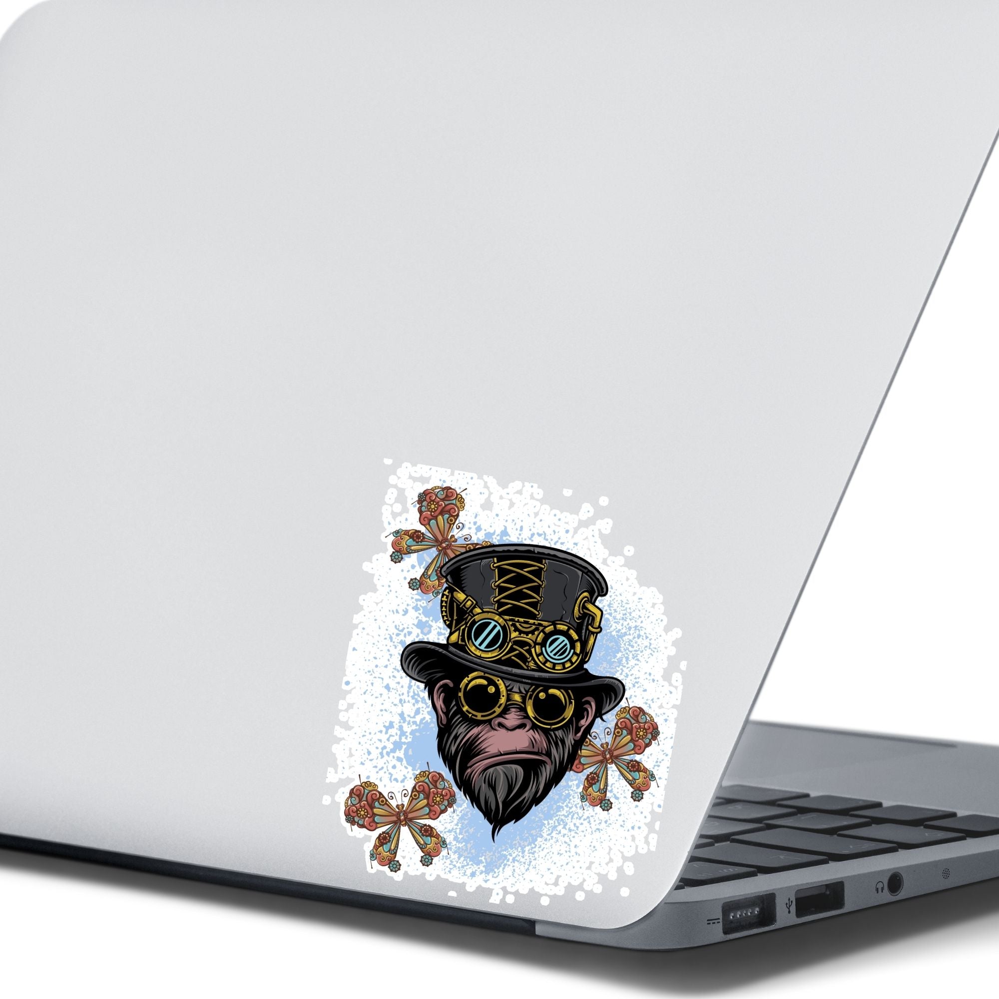 Steampunk Monkey has his own version of a steampunk hat and goggles, plus he is wearing goggles and surrounded by three steampunk butterflies. All on a blue and white background. This image shows the steampunk monkey sticker on the back of an open laptop.