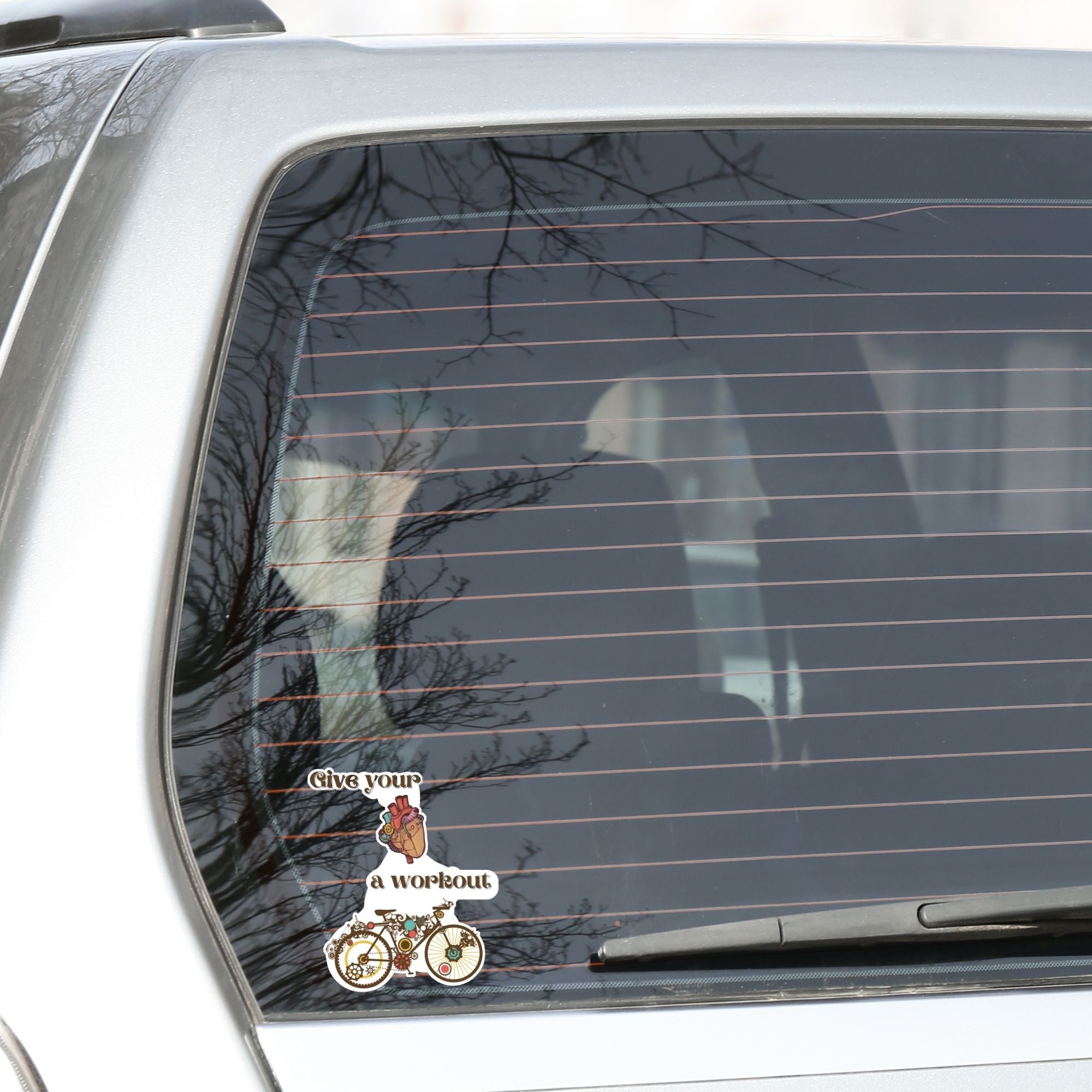 Give your heart a workout! This steampunk sticker has a steampunk anatomic heart and a steampunk bicycle. This image shows the steampunk workout sticker on the rear window of a car.