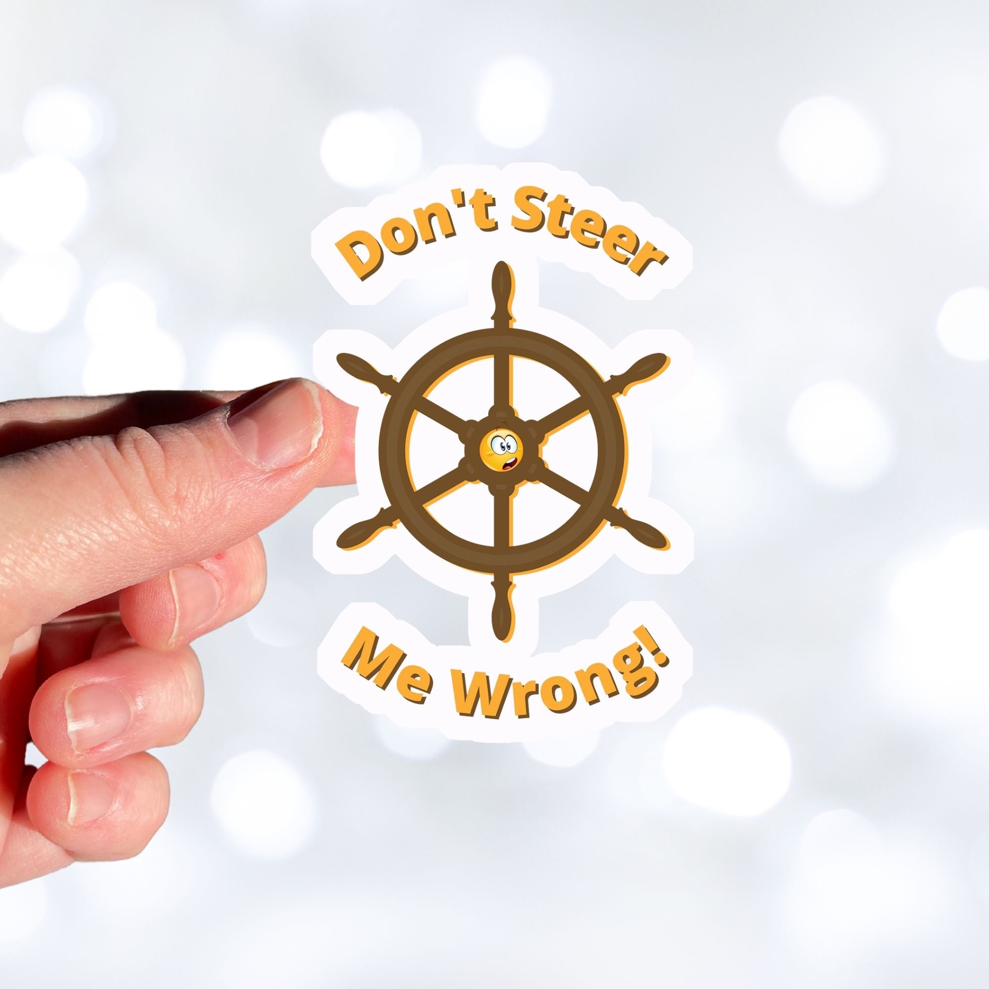 Don't Steer Me Wrong - good words to live by! This individual die-cut sticker features a wooden ship's wheel (tiller) with a shocked emoji face in the center and the words "Don't Steer Me Wrong!" above and below. This image shows a hand holding the sticker.