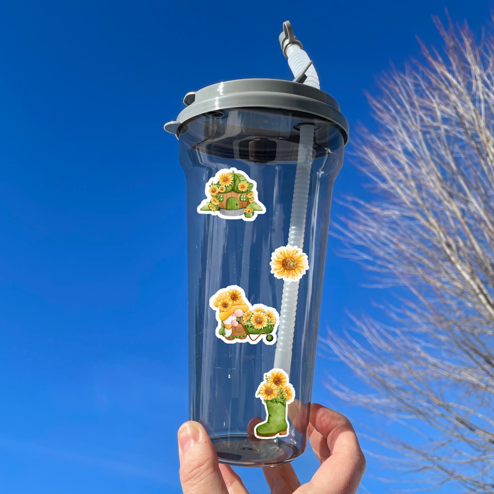 Sunflowers and Gnomes; what a perfect combination! This sticker is filled with stickers of sunflowers and gnomes with sunflowers.  This image shows a water bottle with four stickers applied to it - a gnome house with sunflowers, a single sunflower, a gnome with a wheelbarrow filled with sunflowers, and a boot with sunflowers in it.