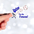 Load image into Gallery viewer, Swing for the Fences! - good for baseball and softball, but also as a metaphor for living our lives! This individual die-cut sticker features a ball player hitting a ball as it moves out towards us with the words Swing for the Fences. Check out our Inspirational collection for more inspiring stickers!  This image shows a hand holding the Swing for the Fences! sticker
