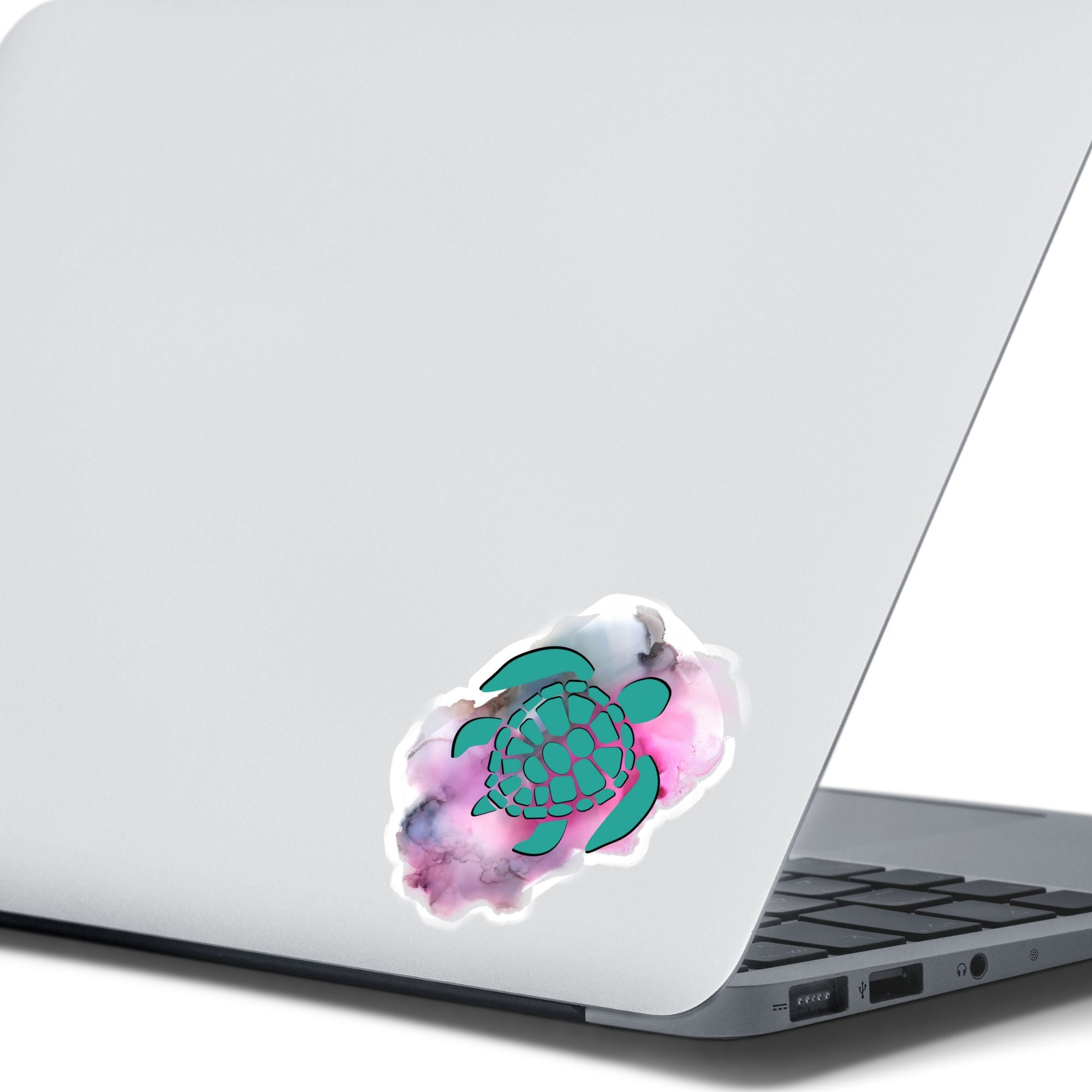 his individual die-cut sticker features a green tribal style turtle on a gray and pink cloudy background. This image shows the turtle sticker on the back of an open laptop.