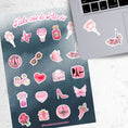 Load image into Gallery viewer,  Celebrate everything Paris with this pink aesthetic on a gray background sticker sheet! Images include the Eifel Tower, perfume, balloons, and flowers. This image shows the sticker sheet next to an open laptop with stickers of balloons, and the Eifel Tower surrounded by flowers, applied below the keyboard.
