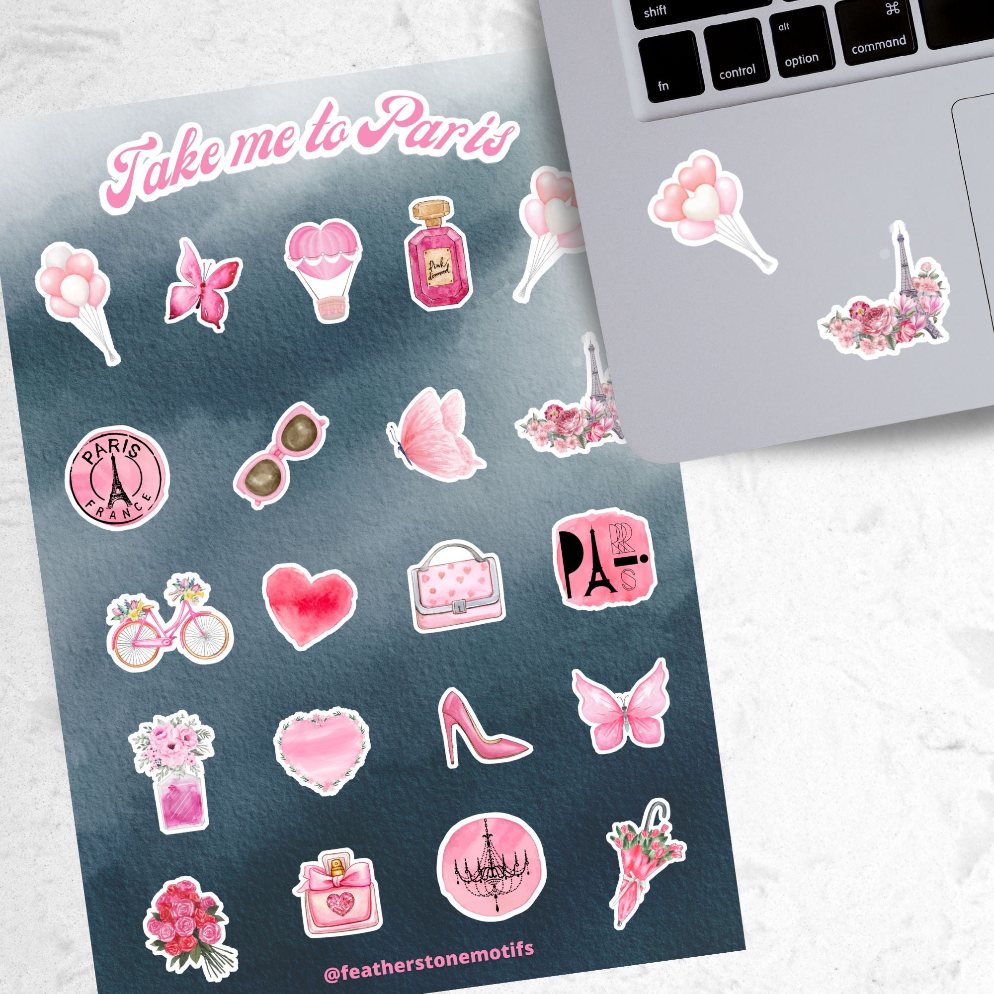  Celebrate everything Paris with this pink aesthetic on a gray background sticker sheet! Images include the Eifel Tower, perfume, balloons, and flowers. This image shows the sticker sheet next to an open laptop with stickers of balloons, and the Eifel Tower surrounded by flowers, applied below the keyboard.