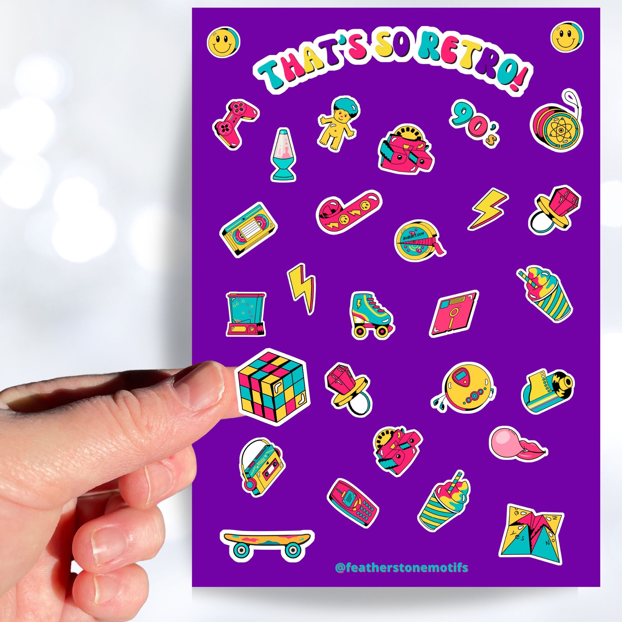 This sticker sheet is filled with images of items from the 70's, 80's, and 90's. Sticker images include a troll doll, roller skate, Rubik's cube, and a skateboard. This image shows a hand holding a Rubik's cube above the sticker sheet.