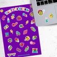 Load image into Gallery viewer, This sticker sheet is filled with images of items from the 70's, 80's, and 90's. Sticker images include a troll doll, roller skate, Rubik's cube, and a skateboard. This image shows the sticker sheet next to an open laptop with stickers of a yo-yo, a smiley face, and a lava lamp, applied below the keyboard.
