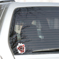 Load image into Gallery viewer, Trash Polka uses red, black, and white with a combination of abstract, surrealistic, and realistic images, and this individual die-cut sticker features a compass inside a red triangle outline on a white background. This image shows the trash polka compass sticker on the back window of a car.
