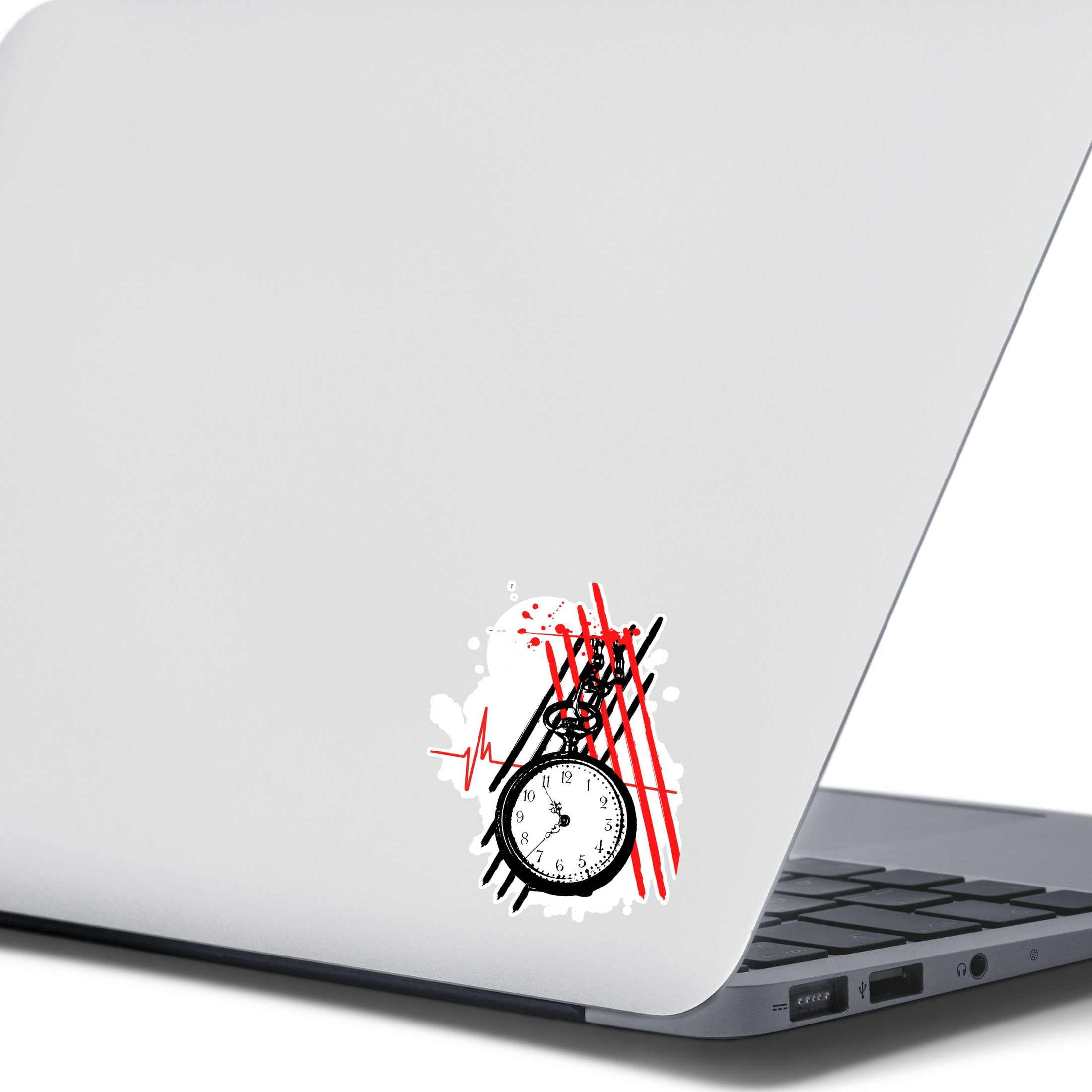 Trash Polka uses red, black, and white with a combination of abstract, surrealistic, and realistic images, and this individual die-cut sticker features a black and white pocket watch with red and black stripes behind.  This image shows the trash polka pocket watch sticker on the back of an open laptop.