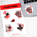 Load image into Gallery viewer, Trash Polka uses red, black, and white with a combination of abstract, surrealistic, and realistic images. This sticker sheet has four larger stickers from our die-cut sticker collection combined with a smaller sticker of a raven flying across a red sun. The stickers are the Trash Polka Lock and Key, Trash Polka Compass, Trash Polka Skull, and Trash Polka Engine. This image shows the sticker sheet next to an open laptop with the Trash Polka Compass sticker applied below the keyboard.
