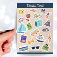 Load image into Gallery viewer, Pack your bags and grab your passport; it's travel time! This sticker sheet is filled with travel related sticker images sure to please even the most discerning traveler. Some of the sticker images are an airplane, suitcase, globe, and ship.  This image is of a hand holding a sailboat sticker above the sticker sheet.
