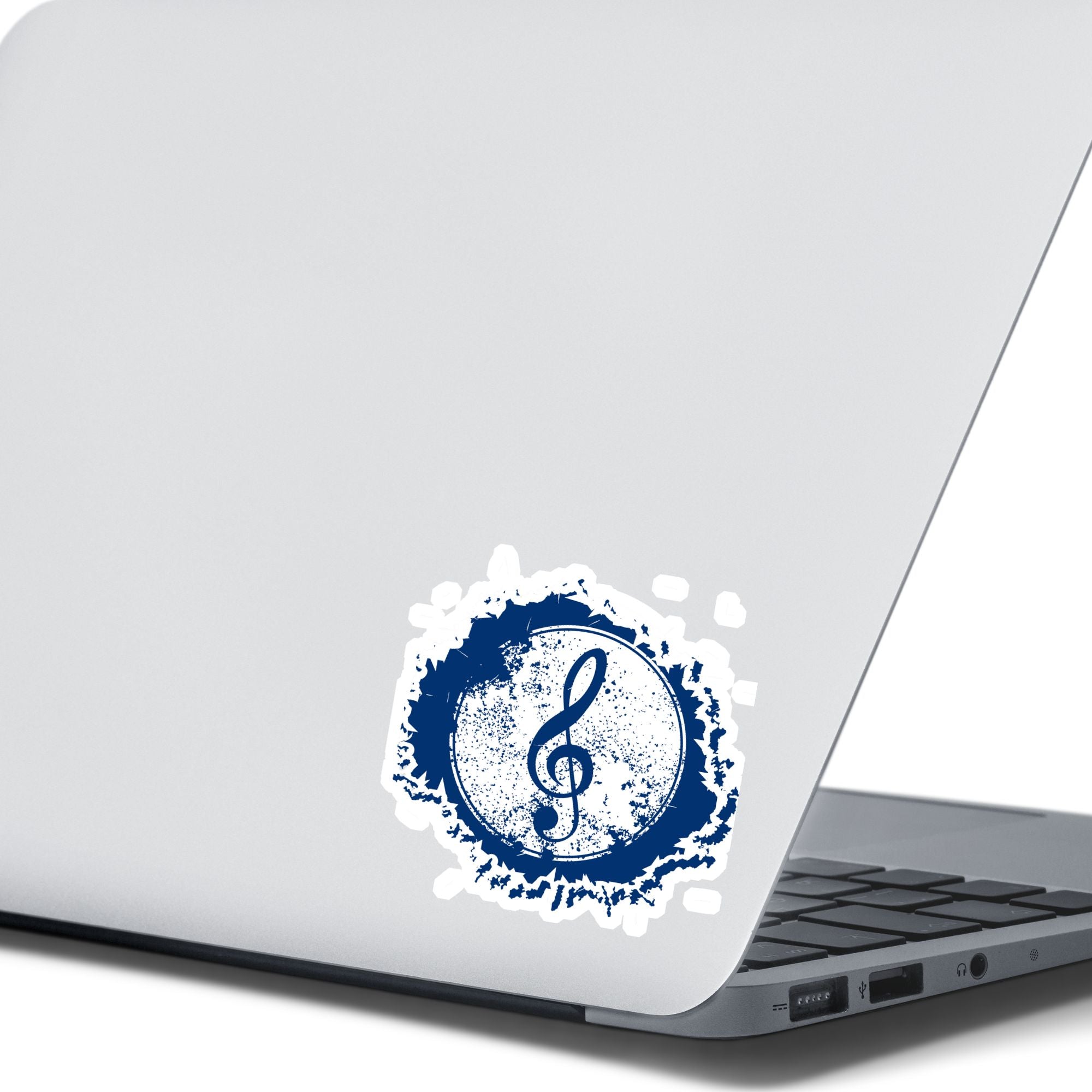 This individual die-cut sticker features a blue treble clef with a paint splattered background. Perfect for performers and music lovers alike!  This image shows the treble clef sticker on the back of an open laptop.