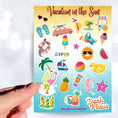 Load image into Gallery viewer, Pack your sunscreen and flip flops for a Vacation in the Sun! This sticker sheet is filled with summer vacation sticker images like the sun with sunglasses, a rubber ducky float ring, ice cream, and a sailboat. This image shows a hand holding a sticker of a flamingo with a surfboard above the sticker sheet.
