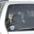 Load image into Gallery viewer, This individual die-cut sticker has a serene looking green sea turtle on a blue and purple background with splash of green. Just looking at this image is relaxing! This image shows the Watercolor Sea Turtle on the back window of a car. 
